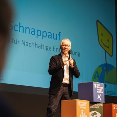 Bayerische Nachhaltigkeitstagung 2022 Nachhaltigkeit und Klimaschutz – notwendiger denn je!: Dr. Werner Schappauf gibt einen Input auf der Bühne