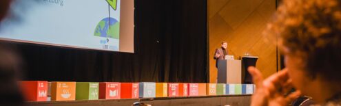 Bayerische Nachhaltigkeitstagung 2023: Nachhaltigkeit in Zeiten knapper Kassen; Martin Heilig, Klimabürgermeister der Stadt Würzburg spricht Grußworte auf der Bühne