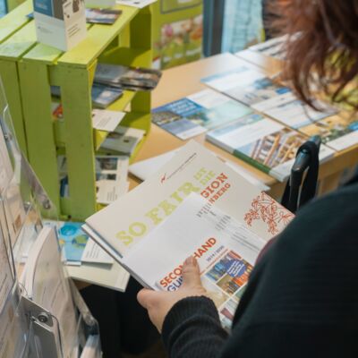 Bayerische Nachhaltigkeitstagung 2019: eine Person hält Broschüren der Fairen Metropolregion Nürnberg in der Hand