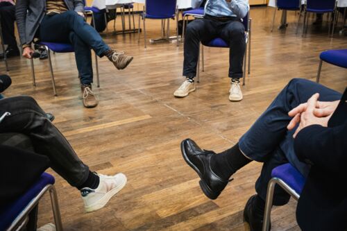 Bayerische Nachhaltigkeitstagung 2022 Nachhaltigkeit und Klimaschutz – notwendiger denn je!: Teilnehmende sitzen in einem Stuhlkreis bei der Fishbowl-Diskussion. Es sind nur die Beine und Füße zu sehen.